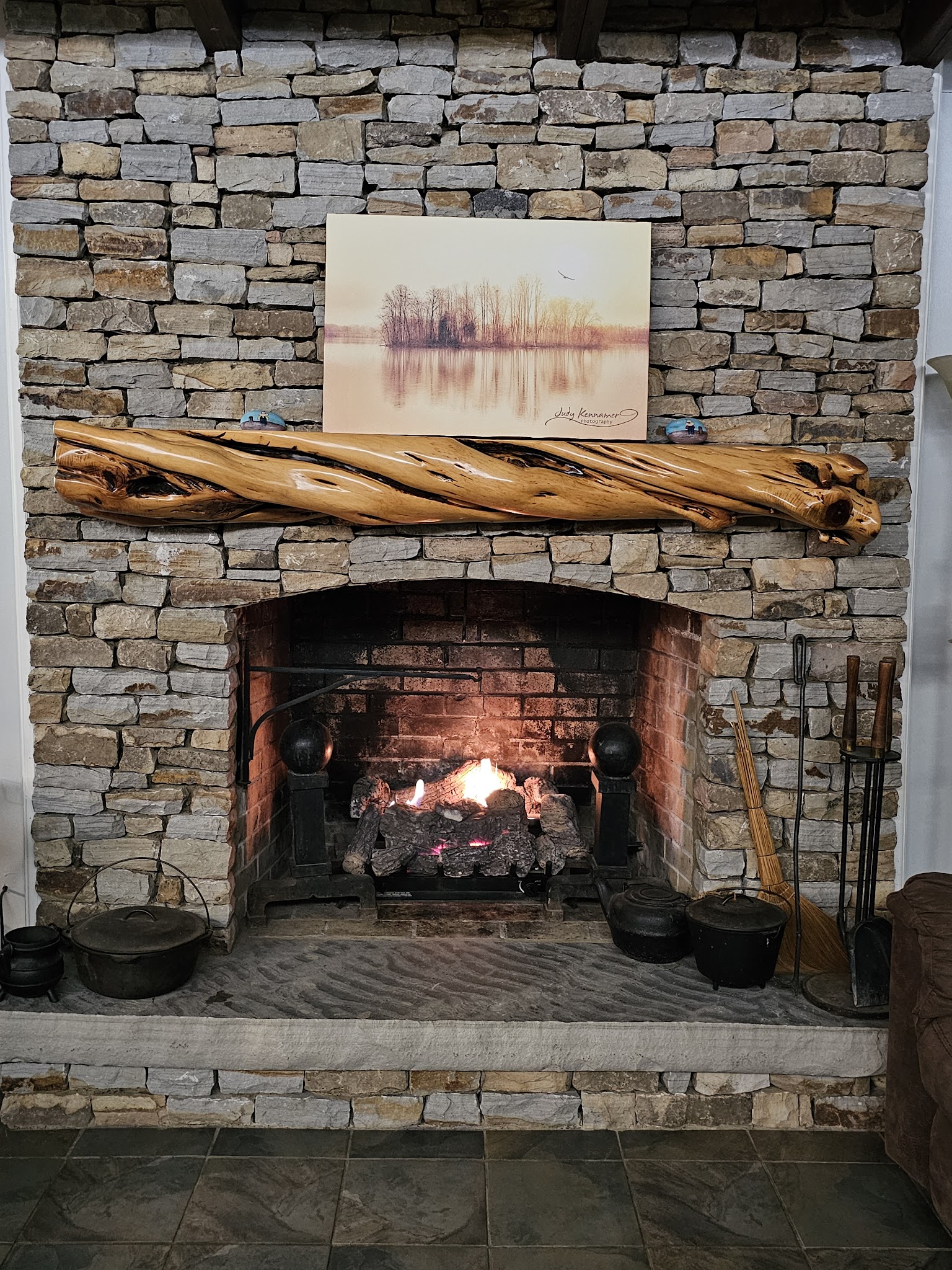 Stone fireplace burning at Guntersville Getaway during a winter extended stay